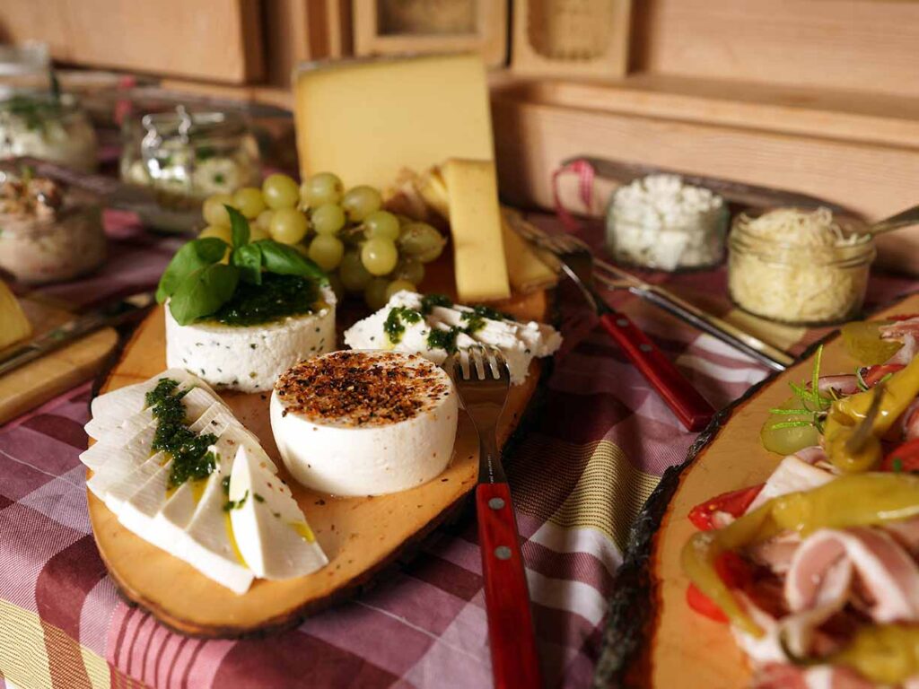 Bergfrühstück auf Alpe mit verschiedenen Käsesorten auf Holzbrett serviert