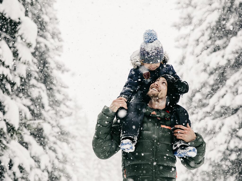 Vater und Sohn beim Winterwandern in winterlichem Wald