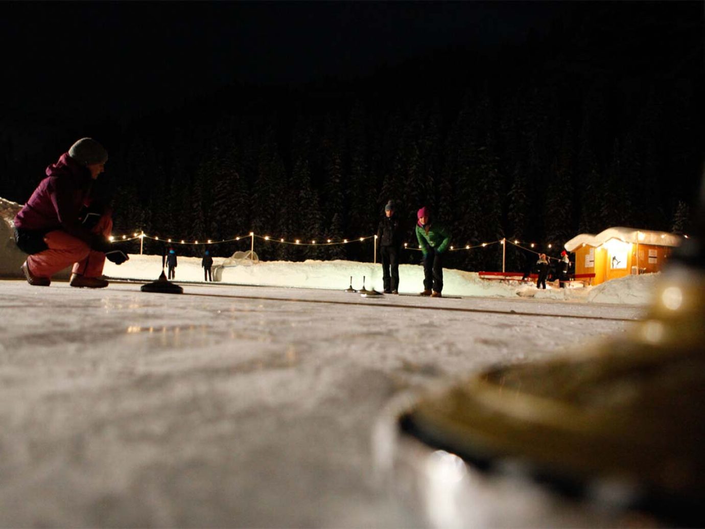 Menschen am Eisstockschiessen in Lech in der Nacht