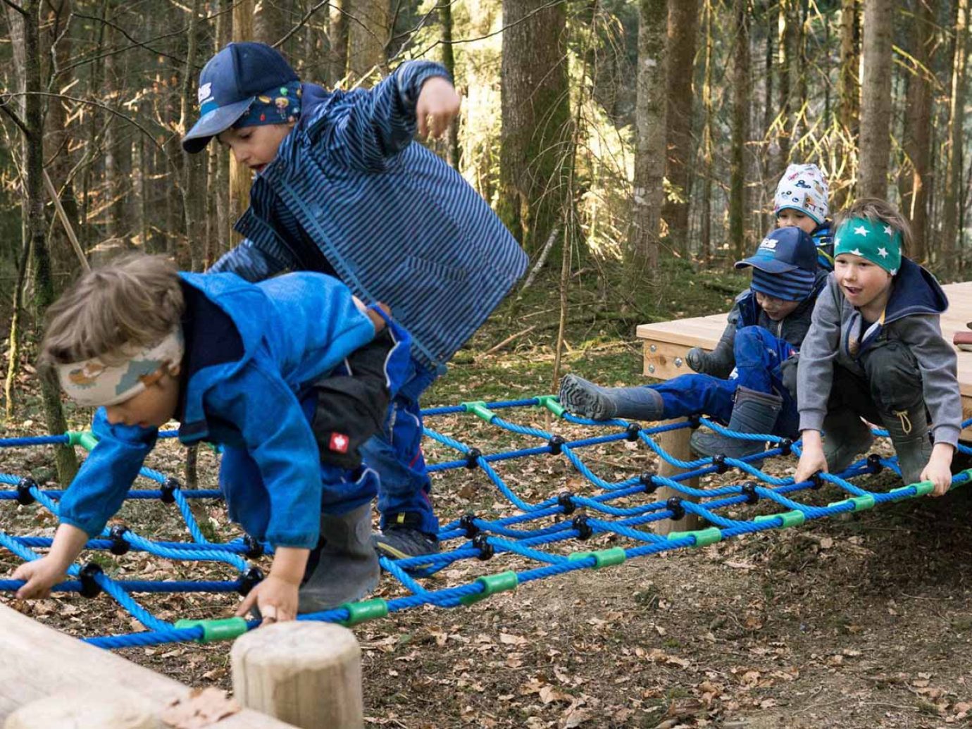 Fünf Kinder am Spielen beim Erlebnisparcours im Wald in Doren