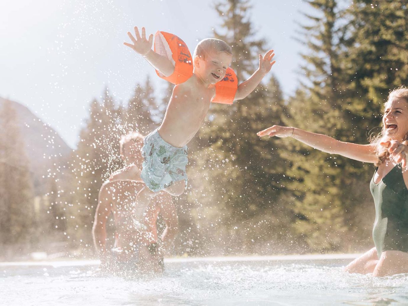 Eltern mit einem Kind mit Schwimmflügel im Schwimmbecken in Lech am Arlberg