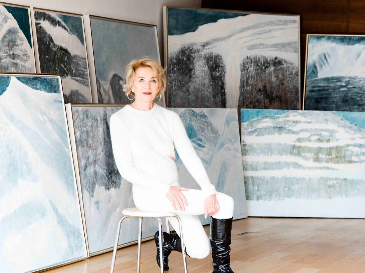 Künstlerin Daisy Hoch sitzt in Galerie vor ihren Schneegemälden