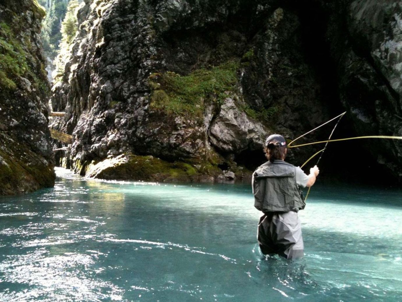 Ein Angler steht im Gewässer im Lechbach am Arlberg